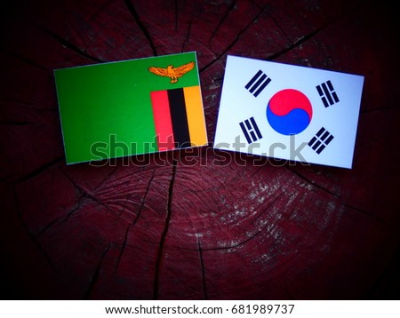 Zambian flag with South Korean flag on a tree stump isolated