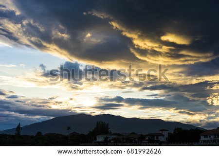 Dramatic sky with dark clouds above the mountain at sunset.