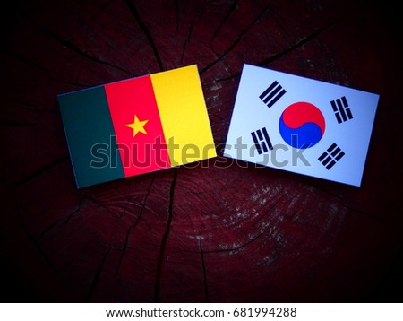 Cameroon flag with South Korean flag on a tree stump isolated
