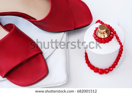 Fashion and accessories concept. Handbag and female footwear with bottle of perfume