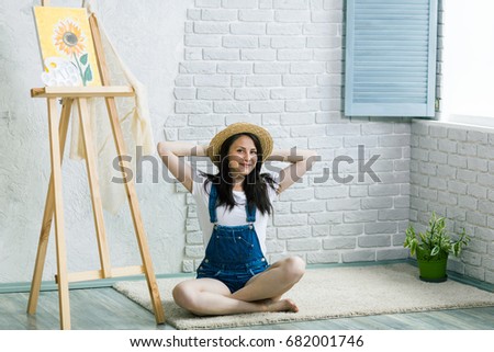Getting creative. Woman artist painting a sunflower at home