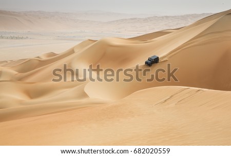 car driving in Rub al Khali Desert at the Empty Quarter, in Abu Dhabi, United Arab Emirates