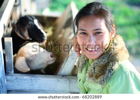 young asian female smiling in goat barn