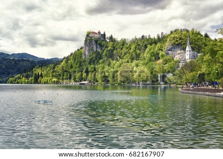 Lake Bled in spring, Slovenia. Lake is in the middle of the Julian Alps ans is a famous spot for tourists. The Bled Castle is on the high spot with trees around.