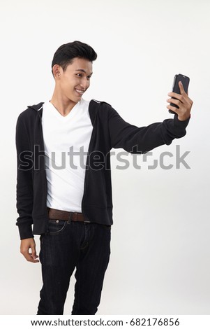 malay teenage doing selfie with his smart phone