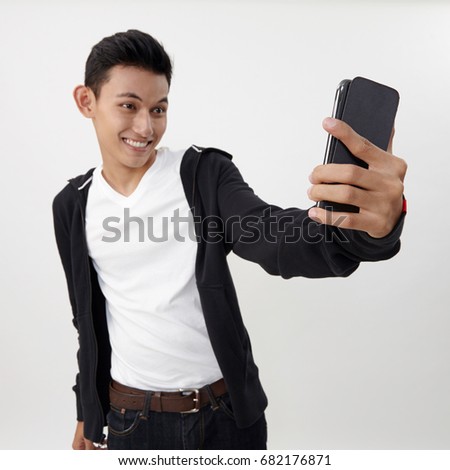 malay teenage doing selfie with his smart phone