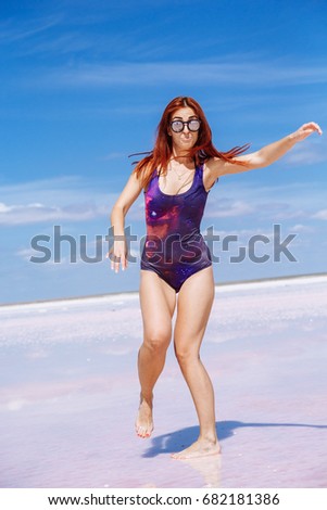 Young beautiful girl on a salt pink lake