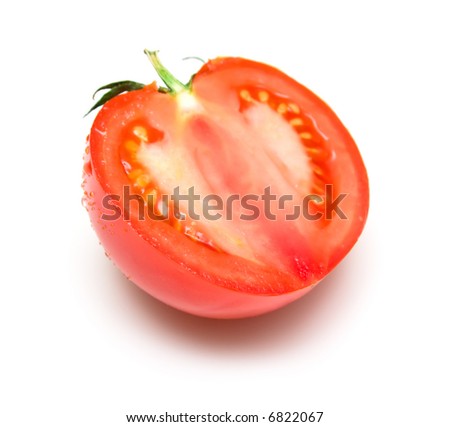 The ripe tomato covered by drops of water and cut half-and-half isolated on white.