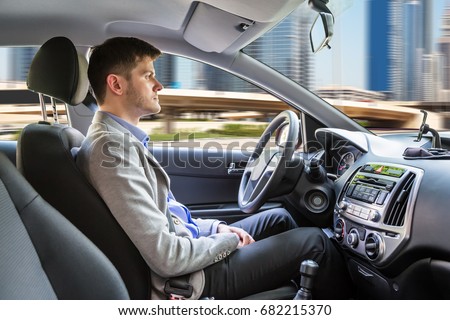 Side View Of A Young Man Sitting Inside Autonomous Car Royalty-Free Stock Photo #682215370
