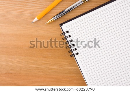 notebook and pens on wood table