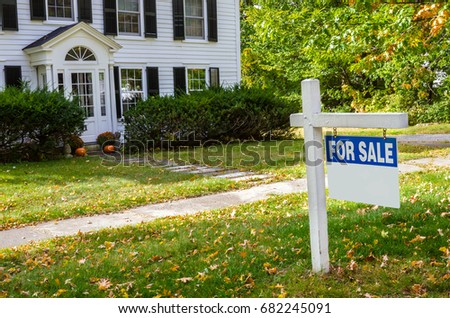 Real Estate Sign in Front of a Traditional Wooden House on Sale