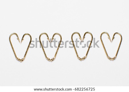 Four hearts made of fishing hooks placed in a row
