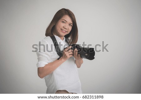 asian woman holding  camera on gray background isolated