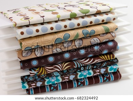 Stack of small bolts of cotton fabric in shades of brown and tan Royalty-Free Stock Photo #682324492