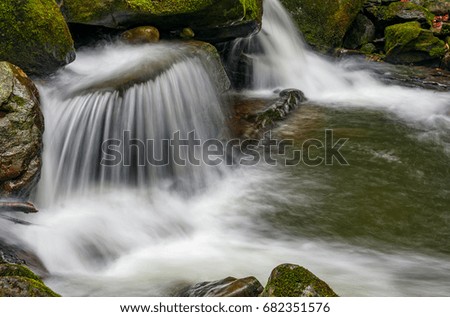 small cascades on the forest river among huge boulders covered with moss. Fresh and clean nature environment. dreamy Carpathian landscape