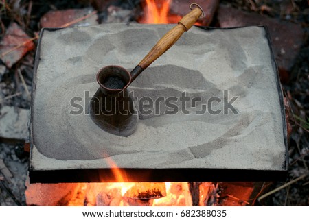 Preparation of coffee in a turk on sand in the open air