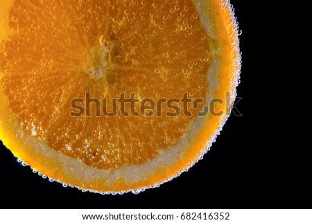 orange in water isolated on black background 