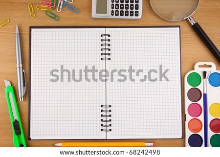 school accessories and checked notebook on wood texture