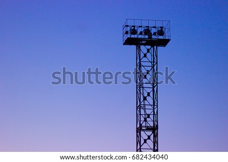 Stadium spot-light tower in a deep dawn evening
