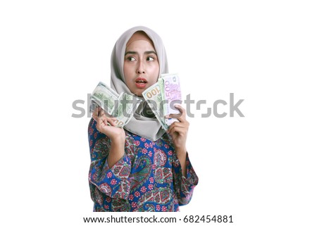Veiled teenage girl holds a handful of money in hand