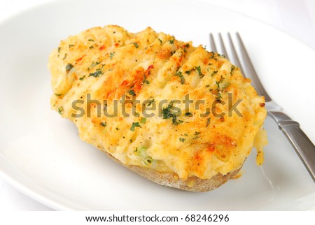 A twice baked potato on a white plate Royalty-Free Stock Photo #68246296