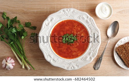soup in a bowl with dill, sour cream and black bread on wooden background - top view - the national dish of Russian and Ukrainian cuisine