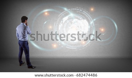 Businessman in modern interior using digital planet earth interface on a wall 3D rendering