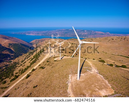 Drone photography of wind turbines on mountain and the sea in distance.
