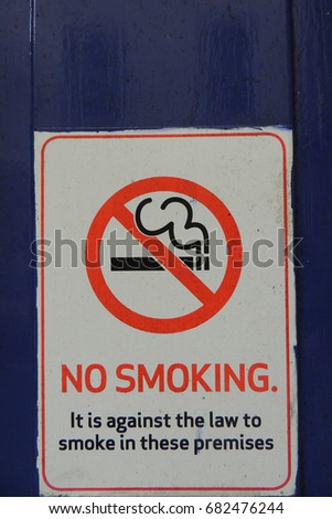 NO SMOKING / Fire escape keep clear - a sign on a blue door in Pike street in Liskeard, Cornwall