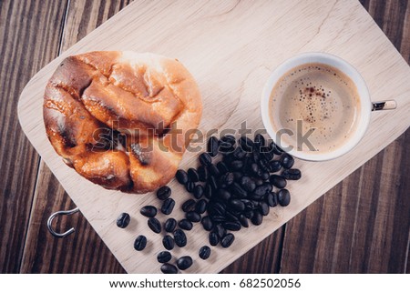 Top view, Coffee cup and beans on dark wooden background, space for texture.