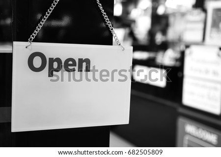 black and white board sign that says Open