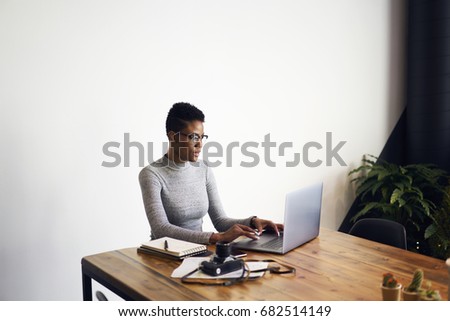 Attractive afro american businesswoman using laptop computer for working online doing distance job in coworking space,professional photographer editing pictures via application on laptop computer