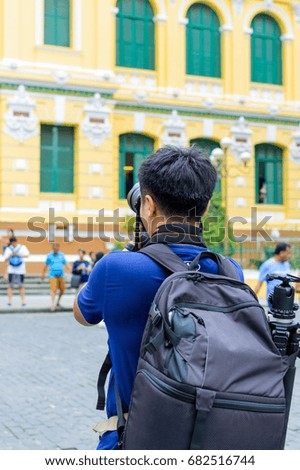 Man tourist taking pictures of landmarks by DSLR camera