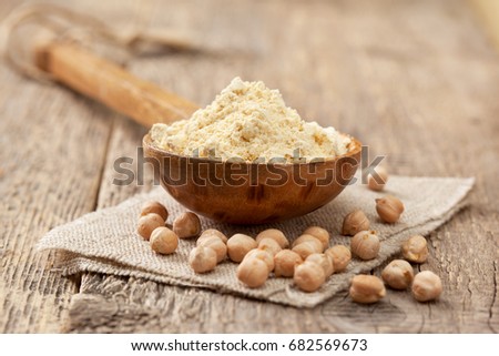 Chickpea flour in a wooden spoon, chickpeas on old wooden background Royalty-Free Stock Photo #682569673