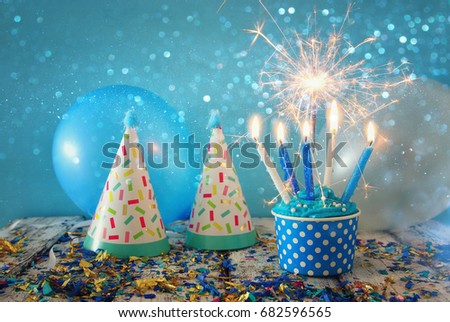 Birthday concept with cupcake and candles on wooden table.