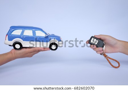 Sale car concept : People hand with blue toy car and car key white background and copy space