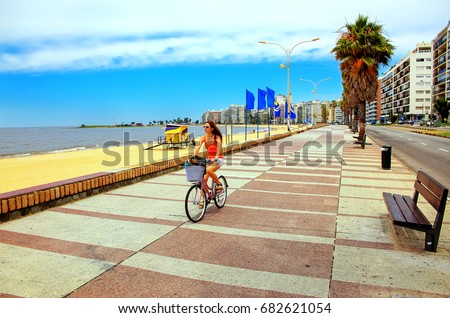 Woman biking on the boulevard along Pocitos beach in Montevideo, Uruguay. Montevideo is the capital and the largest city of Uruguay Royalty-Free Stock Photo #682621054