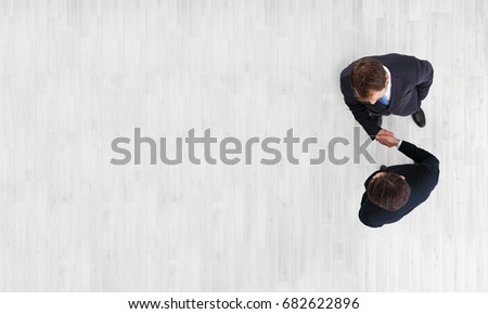 Business men shaking hands, finishing up a meeting, top view with copy space Royalty-Free Stock Photo #682622896