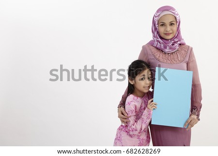 mother and daughter holding a blank placard