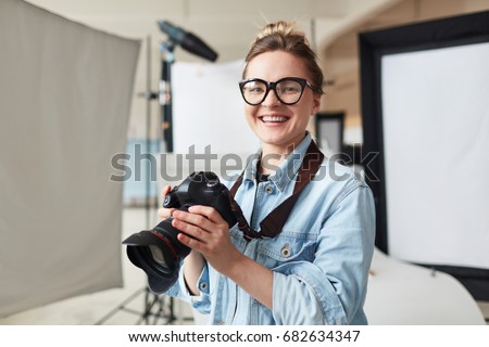 Happy photographer in modern photo-studio Royalty-Free Stock Photo #682634347