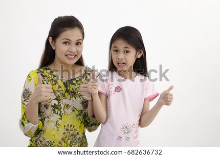 Portrait of happy white mother and young daughter with thumbs up - isolated. Happy family people concept