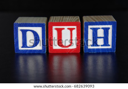 The concept DUH spelled out in toy alphabet block on a black background. Used to comment on an action perceived as foolish or stupid, or a statement perceived as obvious. Royalty-Free Stock Photo #682639093