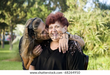 The adult daughter kisses the mother