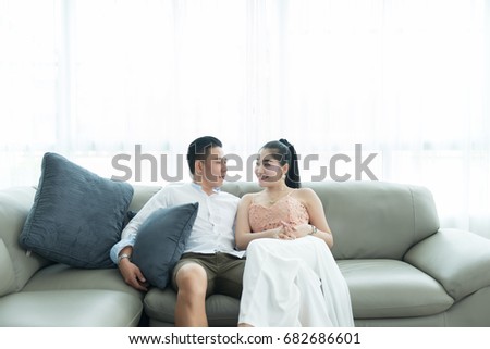 Asian couple on sofa looking eyes together in the livingroom