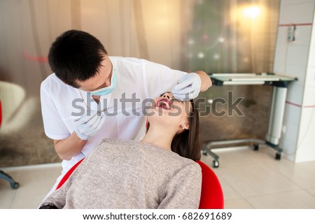 The dentist is treating teeth with a beautiful girl.