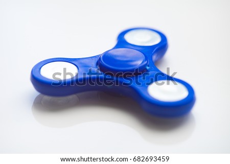 Blue hand Spiner. Stress relieving toy on white background. Close-up. Top view. Stock photo