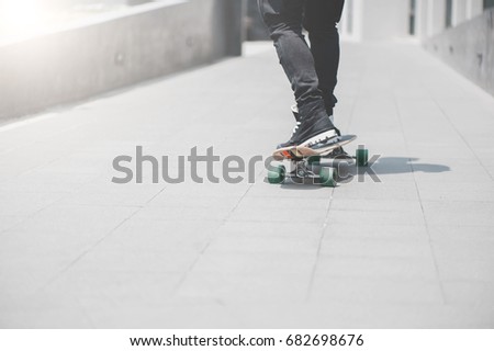 Close up of skater's legs on the longboard riding at the street in outdoors in Bangkok