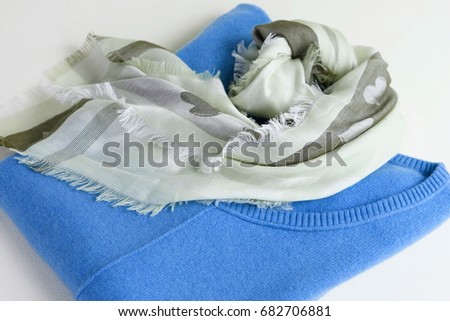 A luxury cashmere pullover blue color, a stylish shawl  on a light background