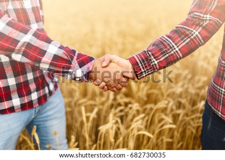 People shaking hands in a wheat field, farmer's agreement. Agriculture agronomist business contract concept Royalty-Free Stock Photo #682730035
