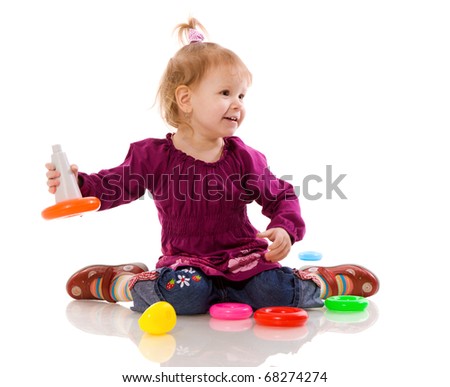 Little girl playing with pyramid isolated on white